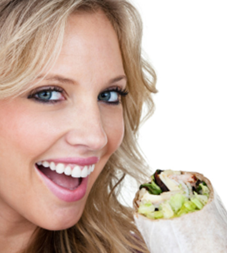Happy woman eating a fresh burrito